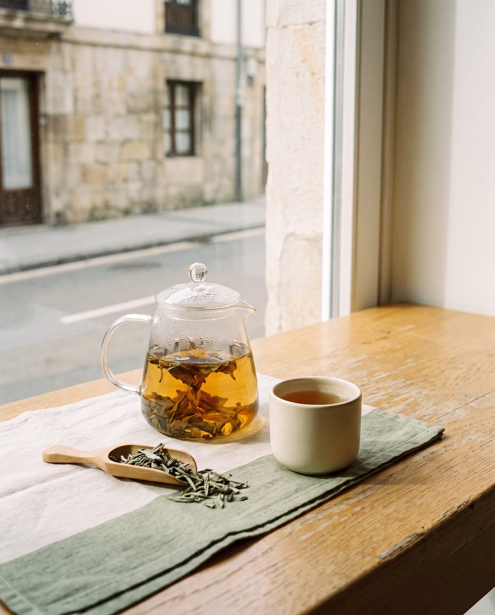 Té en tetera de cristal con las hojas abriéndose